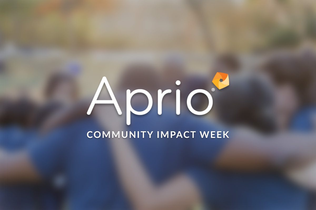 A blurred group of people with arms around each other; overlaid text reads Aprio Community Impact Week with the Aprio logo.