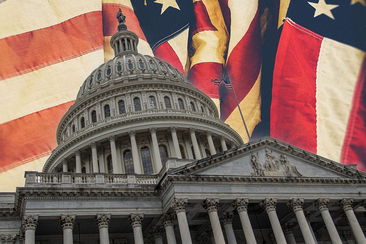 The U.S. Capitol building with several large American flags draped in the background.