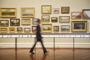 Blurred view of Caucasian security guard walking in art museum