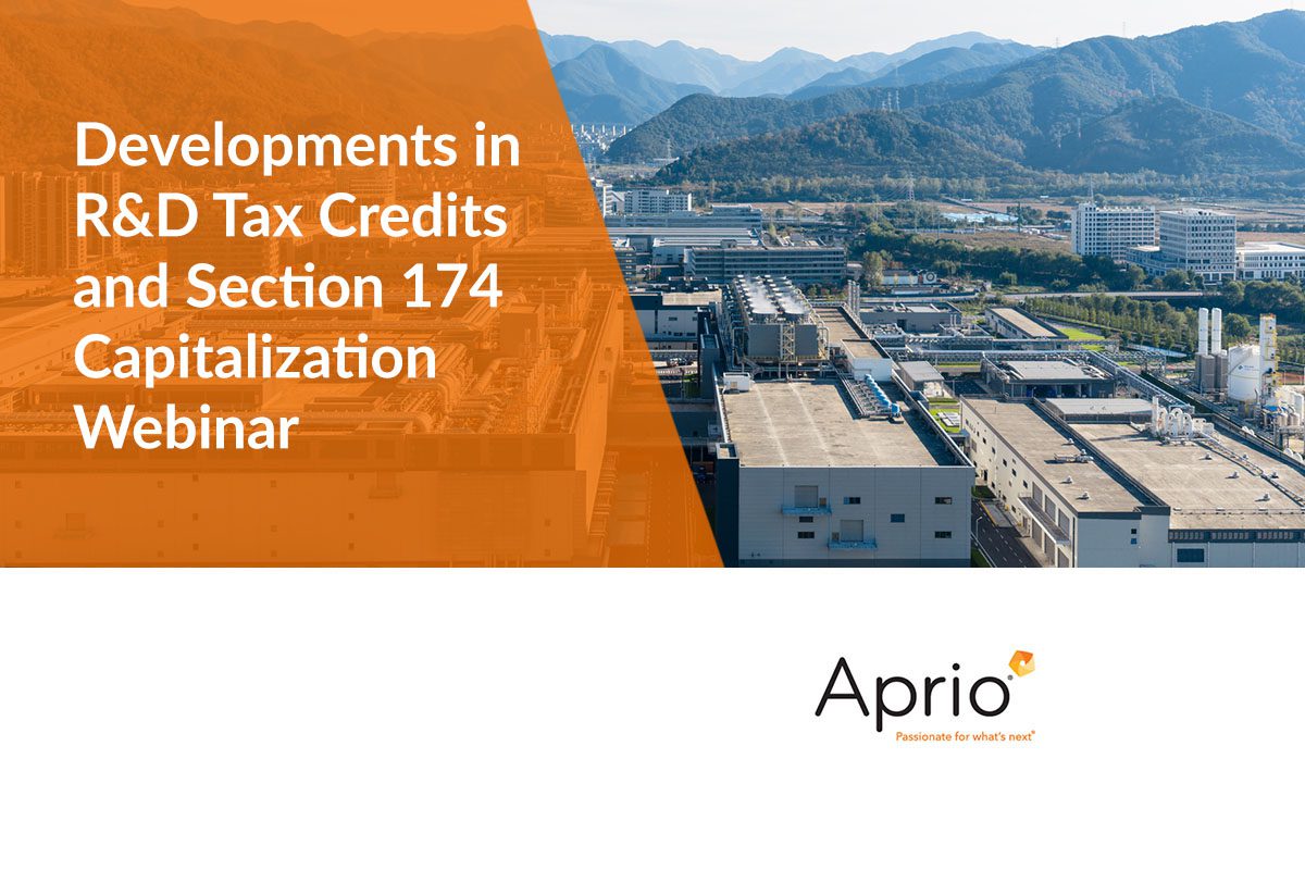 Aerial view of an industrial complex with mountains in the background; text overlay promotes a webinar on R&D tax credits and Section 174 capitalization by Aprio.
