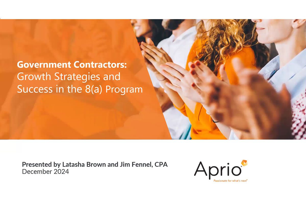 A group of people sitting and clapping, with text overlay about growth strategies and success in the 8(a) program, presented by Latasha Brown and Jim Fennel for Aprio.