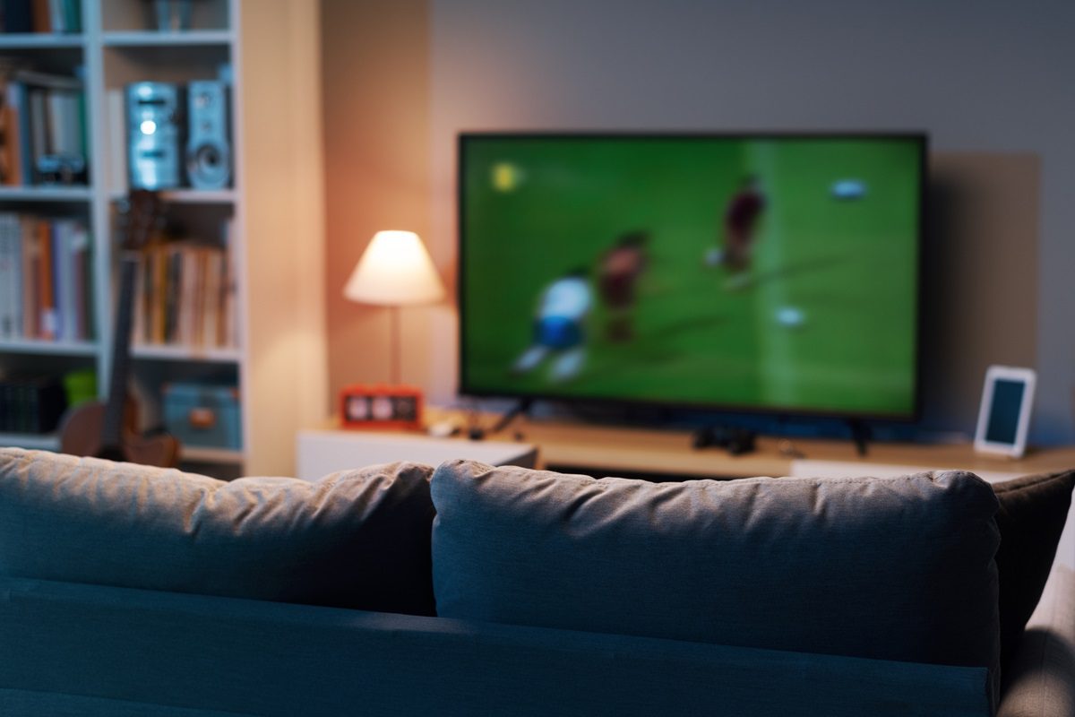 Football match on widescreen flat TV at home, sport and entertainment concept
