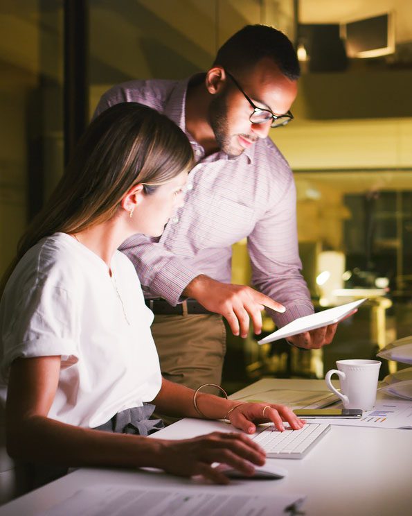 Man and woman at a counter look at something on a tablet