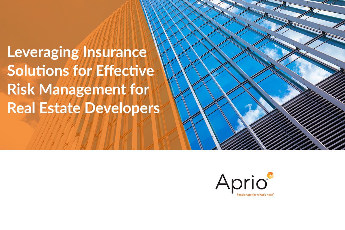 Glass office building exterior with text: Leveraging Insurance Solutions for Effective Risk Management for Real Estate Developers. Aprio logo and slogan appear at the bottom.