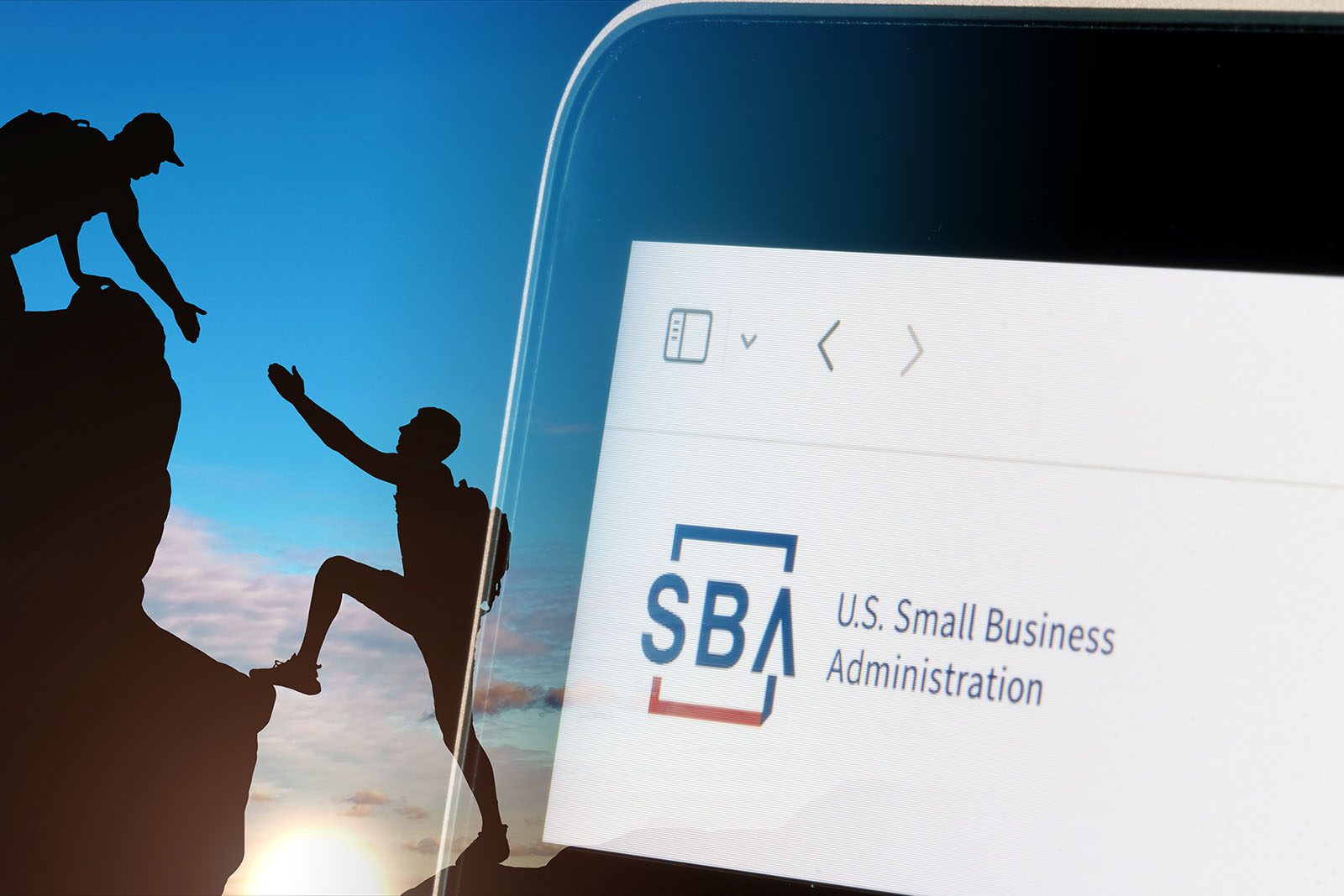 A computer screen shows the U.S. Small Business Administration website, with a background of two hikers, one helping the other up a cliff.