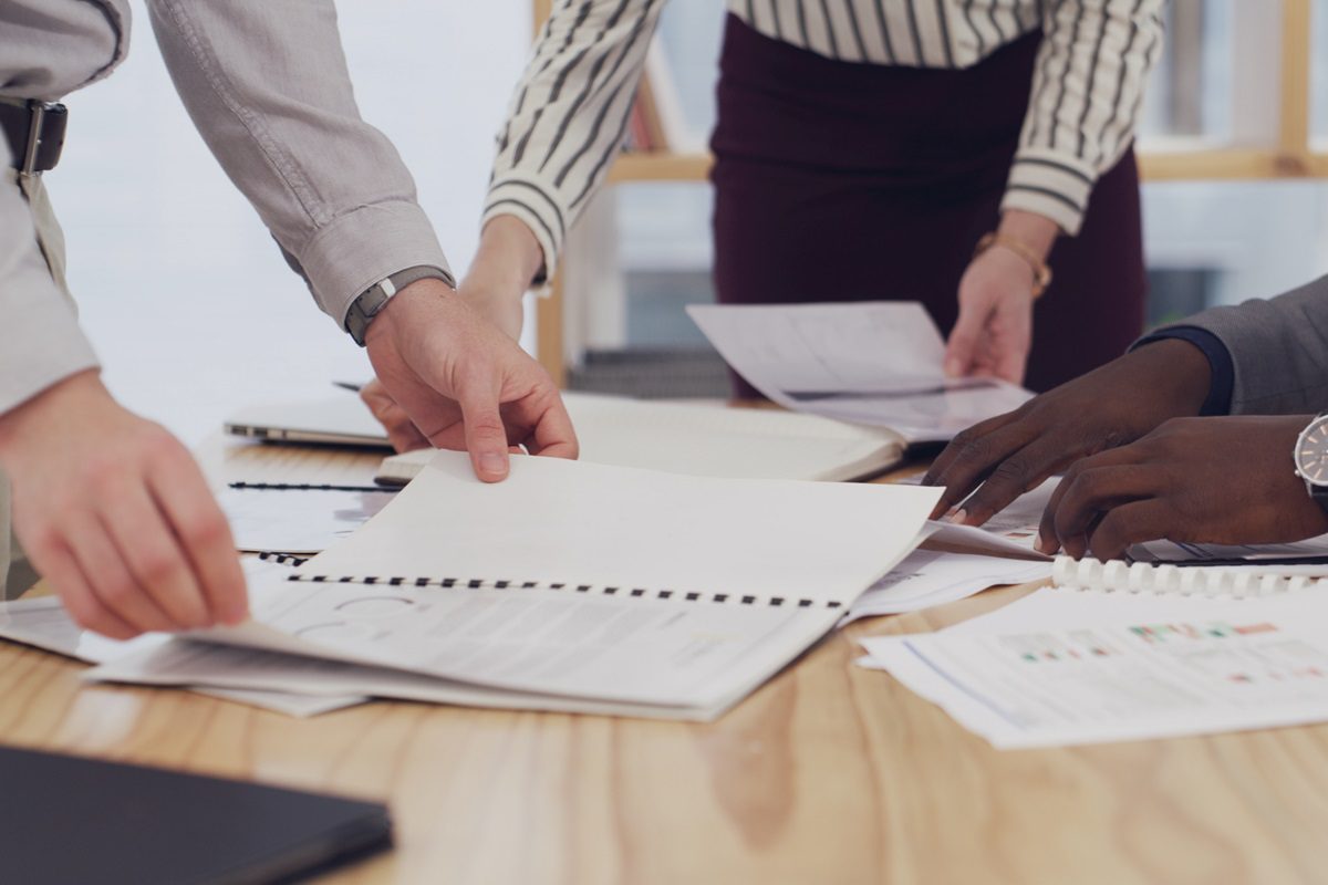 Hands, team and discussion with documents, office or financial analyst with data, people and budget. Accountant, analysis and group with paperwork for business development, meeting or plan with stats