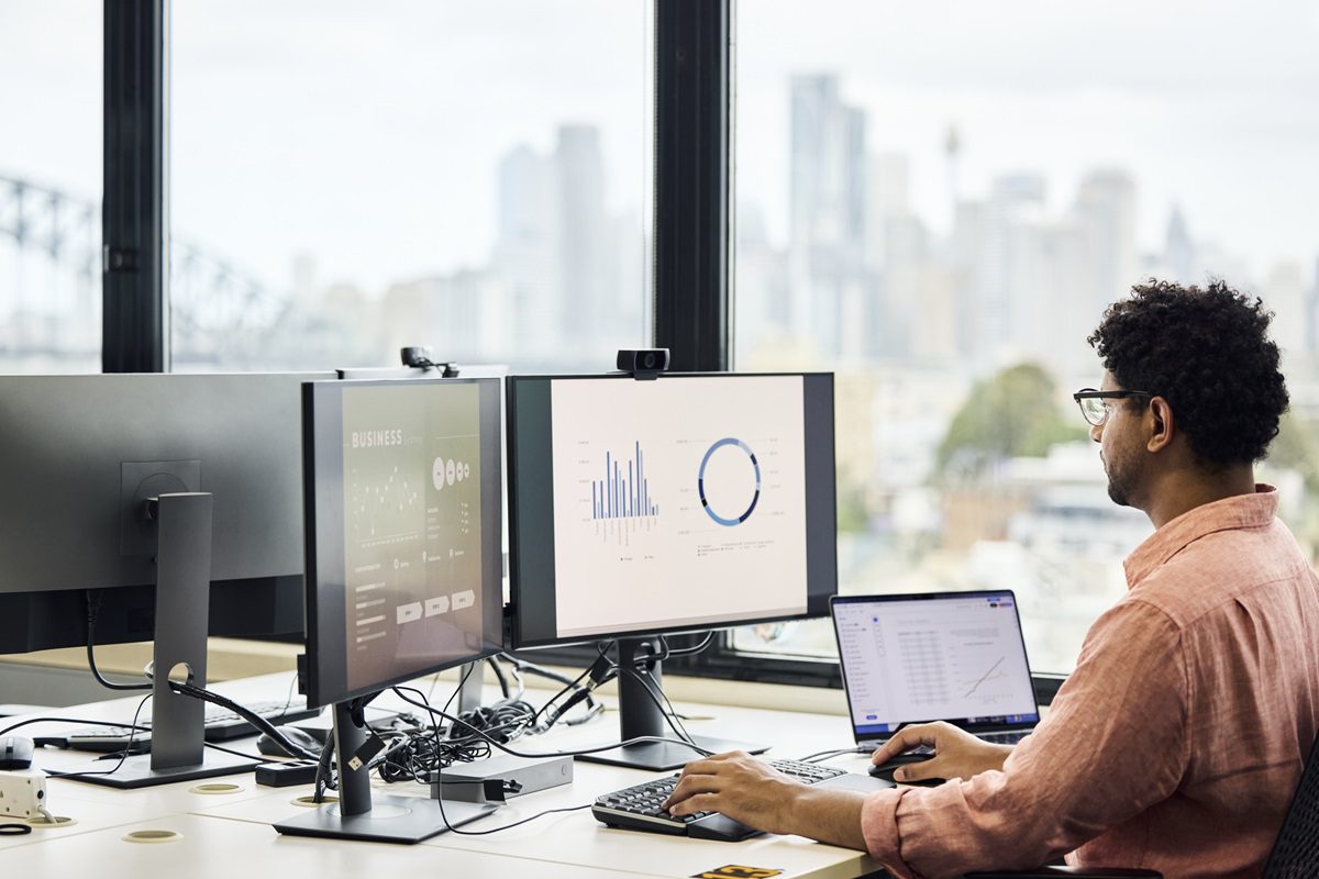 Businessman analyzing sales graph on computer screen at office. Entrepreneur is preparing finance data. He is using keyboard and mouse.