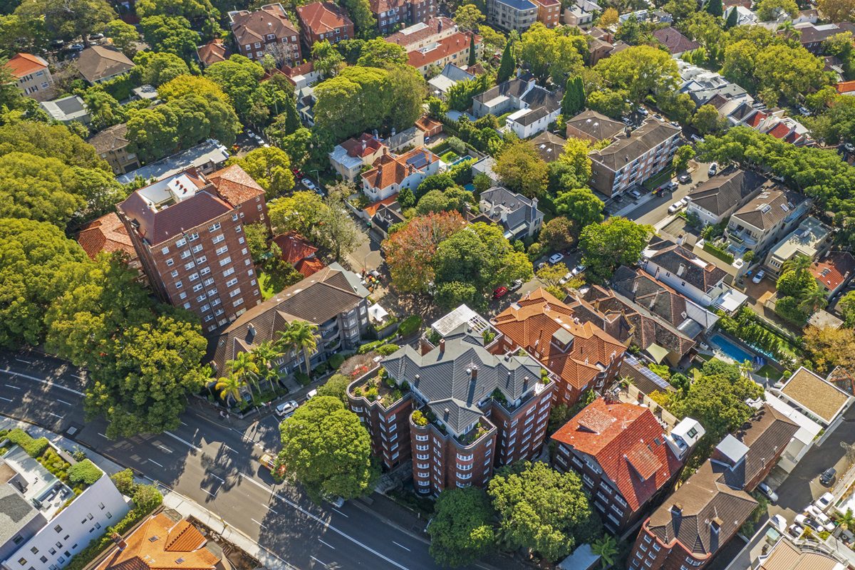 Red brick apartment buildings, houses and trees, aerial view
