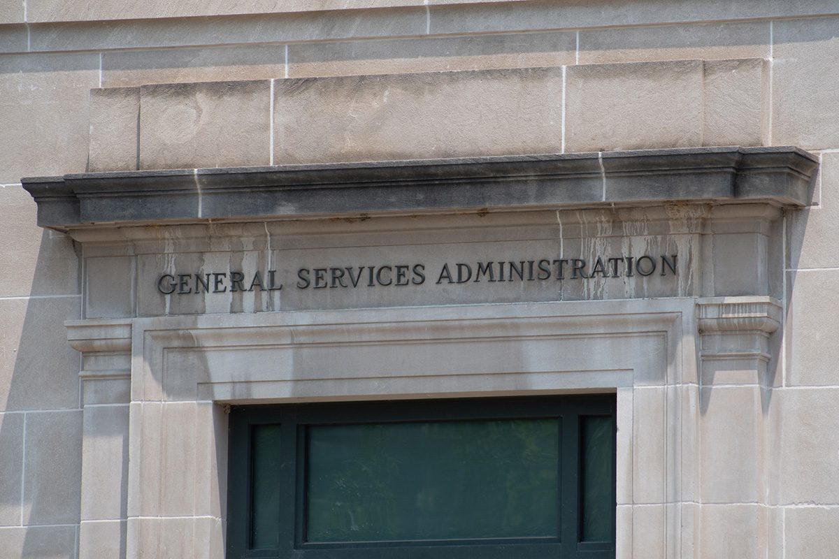 Stone facade with GENERAL SERVICES ADMINISTRATION engraved above a window on a government building.