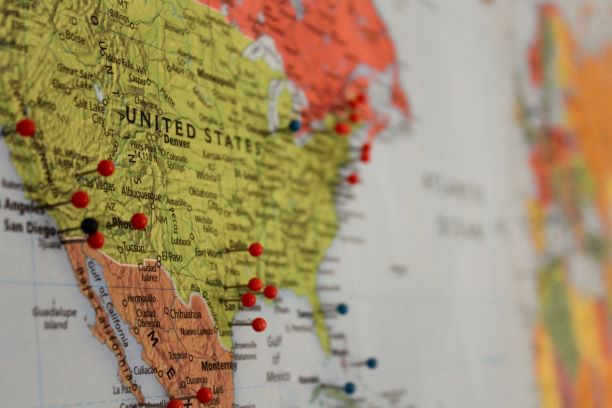 Close-up of a map of North America, primarily showing the United States and Mexico, with various colored pins marking specific locations.